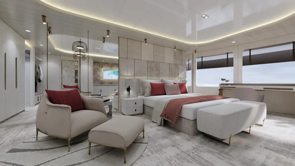 The master suite: a double bed with a burgundy throw, an armchair and footstool, and wide windows